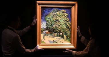 Sotheby's staff handle the "Chataigniers en fleurs" ("Chestnut Trees in Blossom") painting by Vincent Van Gogh at an auction preview, Hong Kong, China, Oct. 13, 2026. (AFP Photo)