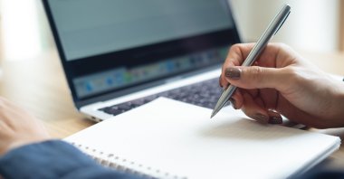 A woman studies on her laptop at home. (Shutterstock Photo)