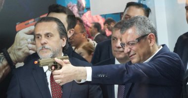 Özgür Özel, then CHP chairperson, tests a gun during a visit to a defense fair, Istanbul, Türkiye, May 7, 2026. (DHA Photo)