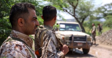 Saudi-backed Yemen government soldiers look on as a pick-up truck drives past near the Jabal Han front, west of the city of Taiz, Yemen, Oct. 3, 2026. (AFP Photo)