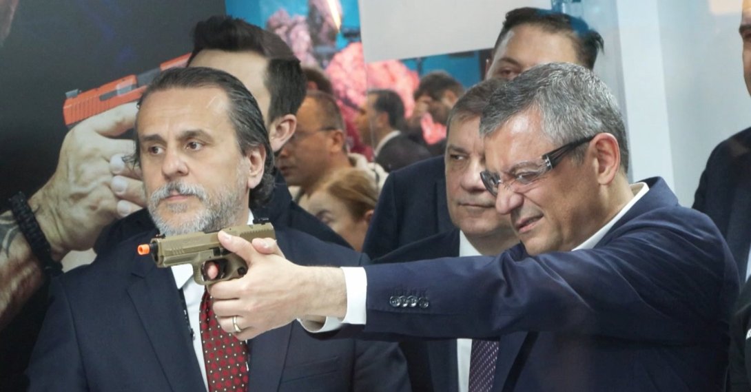 Özgür Özel, then CHP chairperson, tests a gun during a visit to a defense fair, Istanbul, Türkiye, May 7, 2026. (DHA Photo)