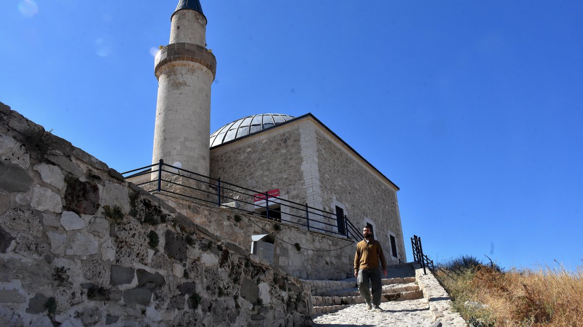 Sibğatullah Bilmez walks along the steep and rugged path leading to the historic Suleyman Han Mosque atop Van Castle, Van, Türkiye, Oct. 7, 2026. (AA Photo)