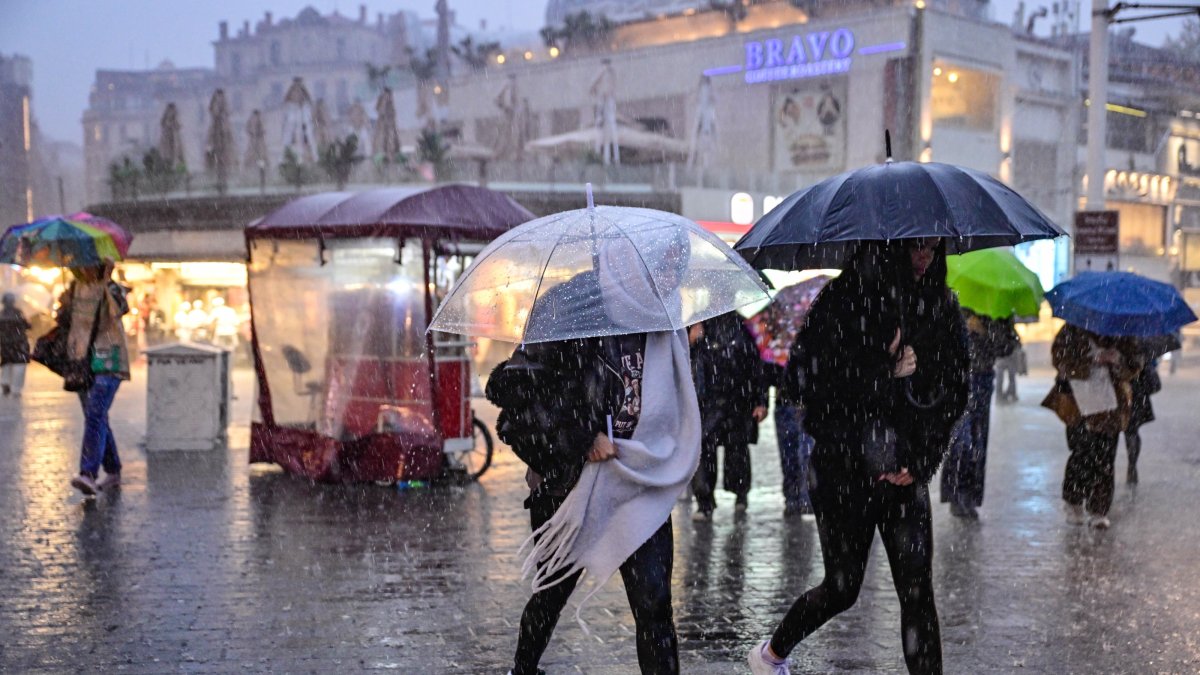 People walk through heavy rain in Taksim Square as downpours hit the city, Istanbul, Türkiye, Oct. 14, 2026. (AA Photo)