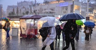 People walk through heavy rain in Taksim Square as downpours hit the city, Istanbul, Türkiye, Oct. 14, 2026. (AA Photo)