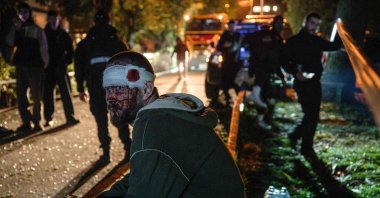 A wounded resident sits at the site of a Russian missile strike at an apartment building in Kyiv, Ukraine, Oct. 14, 2026. (AFP Photo)