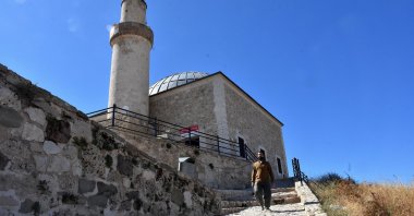 Sibğatullah Bilmez walks along the steep and rugged path leading to the historic Suleyman Han Mosque atop Van Castle, Van, Türkiye, Oct. 7, 2026. (AA Photo)