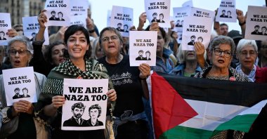 People show signs and a Palestinian flag during a demonstration in support of the "NAZA" documentary film by Israeli directors Yuval Abraham and Rachel Szor during the 74th San Sebastian International Film Festival in the northern Spanish Basque city of San Sebastian, Spain,  Sept. 25, 2026. (AFP Photo)
