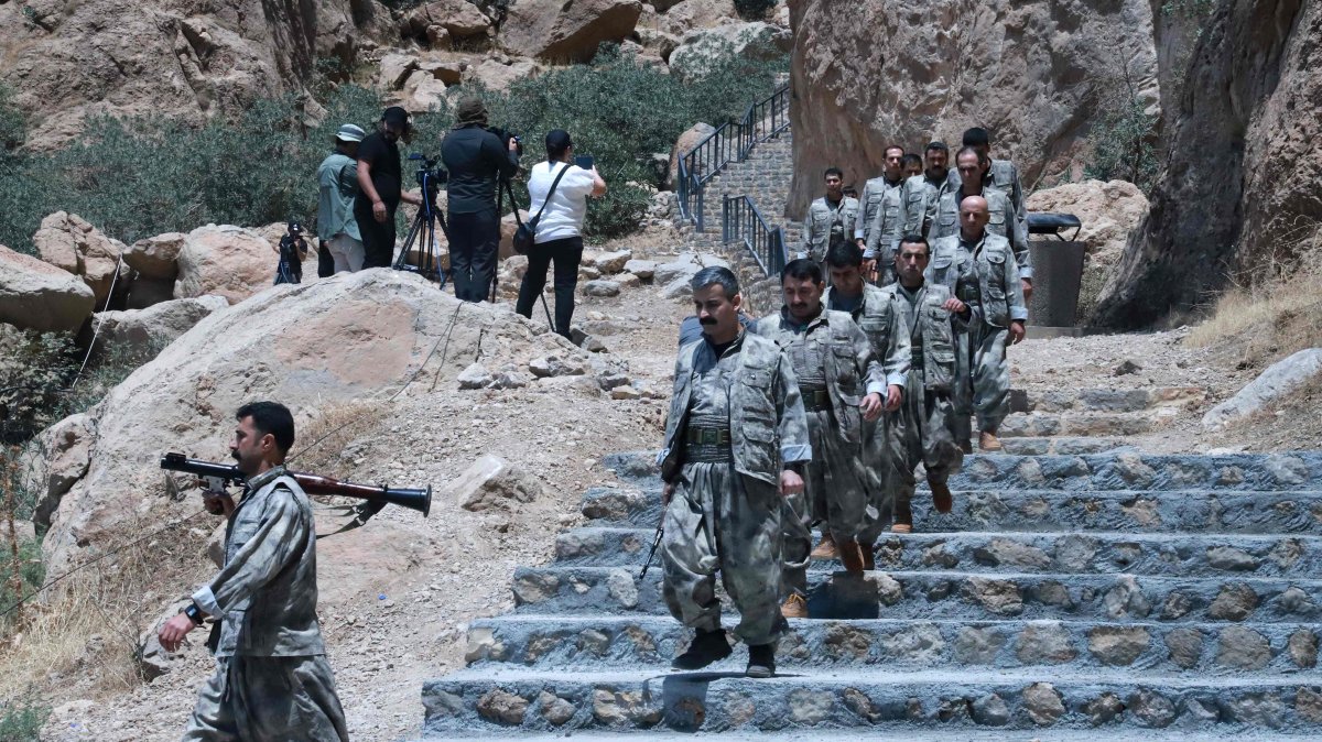 PKK members descend stairs ahead of a ceremony to burn their weapons to symbolize the beginning of disarmament, Sulaimaniyah, KRG, July 11, 2025. (AFP Photo)