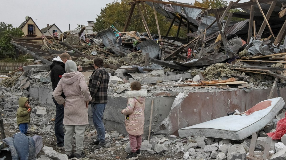 Residents stand at the site of a private house destroyed during a Russian airstrike on the outskirts of Dnipro, Ukraine, Oct. 15, 2026. (Reuters Photo)