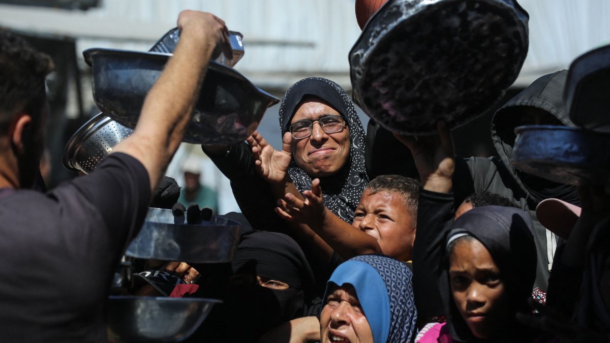 Nihaya Al-Masri, a 35-year-old displaced Palestinian woman from Beit Hanoun, waits to receive food for her family at a charity kitchen in Khan Younis, in the southern Gaza Strip, Oct. 6, 2026. (AFP File Photo)