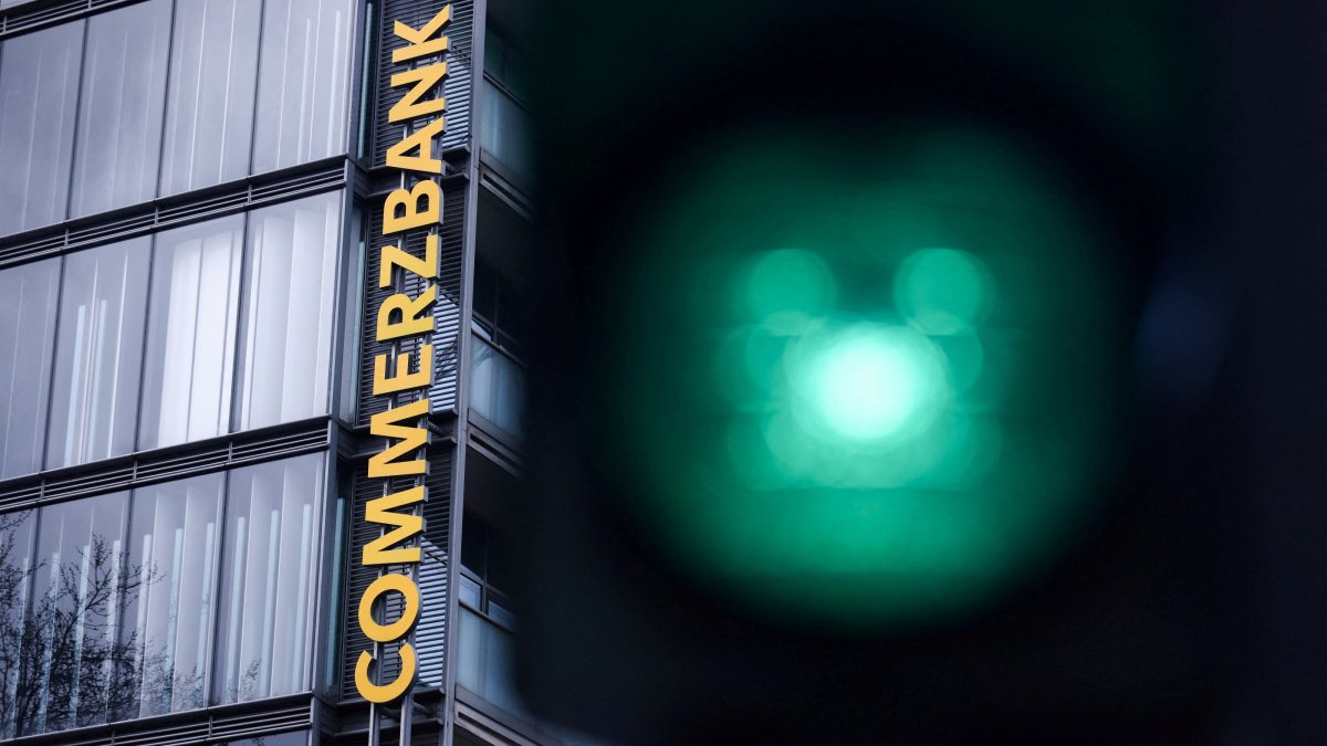 Traffic lights glow near a logo of Commerzbank at a branch in Cologne, Germany, March 16, 2026. (Reuters Photo)