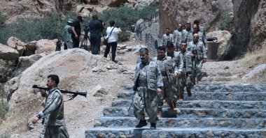 PKK members descend stairs ahead of a ceremony to burn their weapons to symbolize the beginning of disarmament, Sulaimaniyah, KRG, July 11, 2025. (AFP Photo)