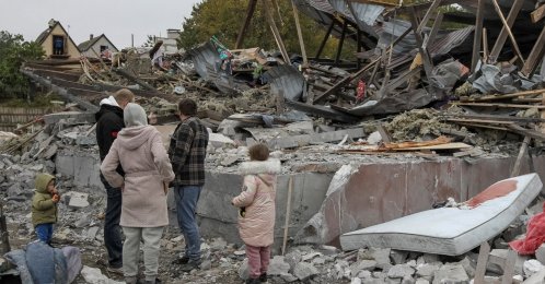 Residents stand at the site of a private house destroyed during a Russian airstrike on the outskirts of Dnipro, Ukraine, Oct. 15, 2026. (Reuters Photo)