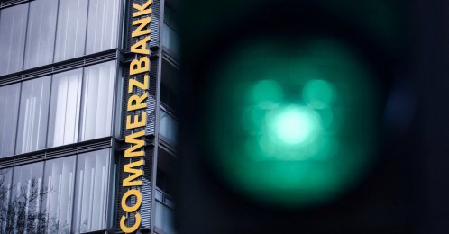 Traffic lights glow near a logo of Commerzbank at a branch in Cologne, Germany, March 16, 2026. (Reuters Photo)