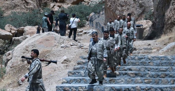 PKK members descend stairs ahead of a ceremony to burn their weapons to symbolize the beginning of disarmament, Sulaimaniyah, KRG, July 11, 2025. (AFP Photo)