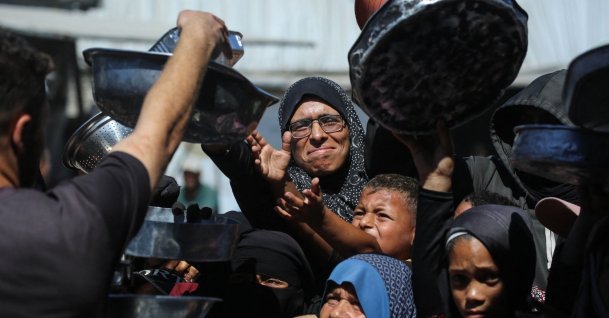 Nihaya Al-Masri, a 35-year-old displaced Palestinian woman from Beit Hanoun, waits to receive food for her family at a charity kitchen in Khan Younis, in the southern Gaza Strip, Oct. 6, 2026. (AFP File Photo)