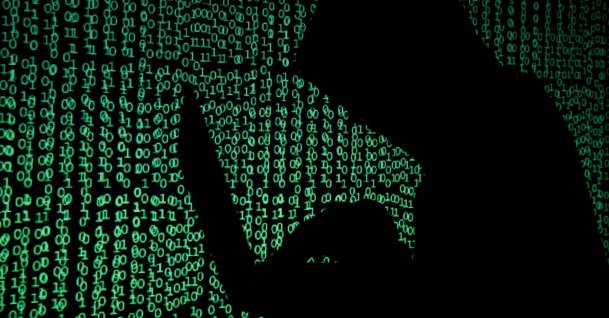 A hooded man holds a laptop computer as cyber code is projected on him in this illustration picture taken on May 13, 2017. (Reuters Photo)