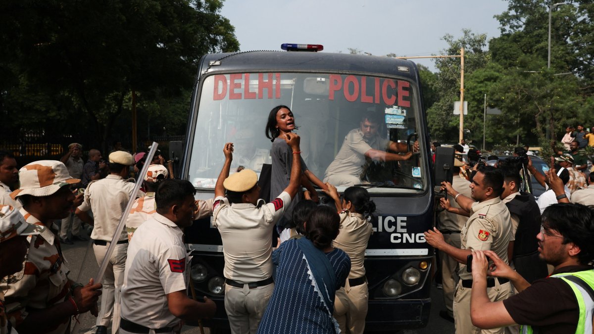 A protester reacts as she tries to stop the police bus carrying detained protesters during a protest organized by the Cockroach Janta Party (CJP), New Delhi, India, Oct. 10, 2026. (Reuters Photo)