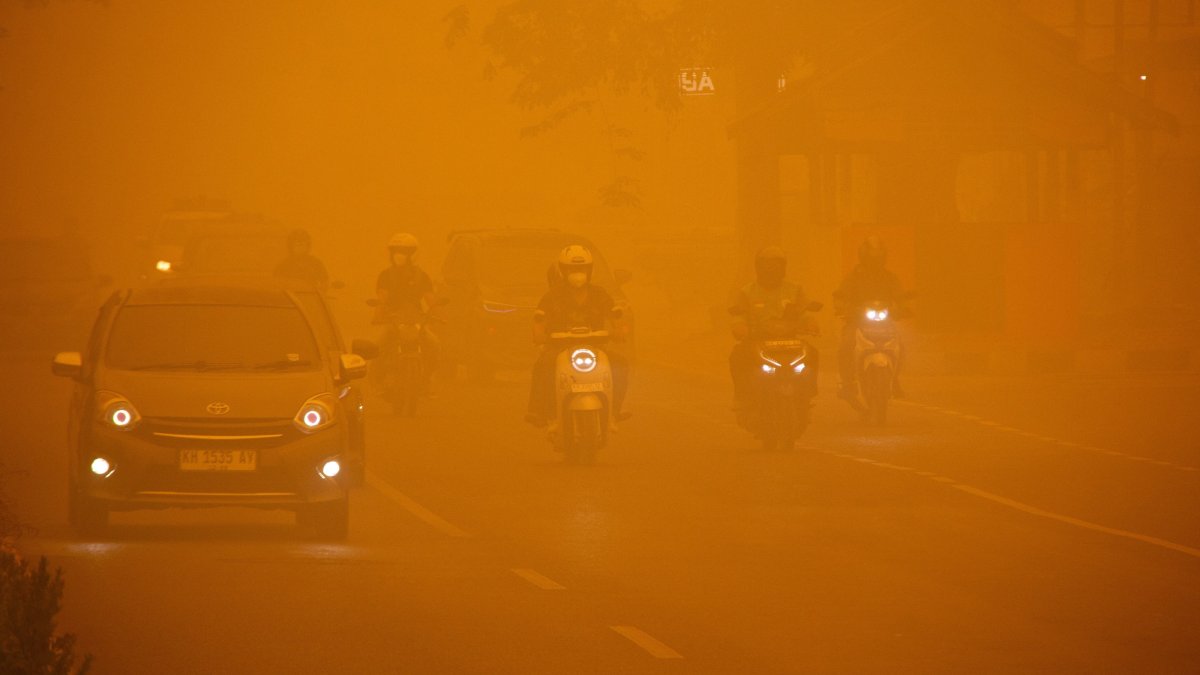 Motorists drive along a main road as haze from wildfires shrouds the area in Palangka Raya, Central Kalimantan province, Indonesia, Oct. 14, 2026. (Reuters Photo)