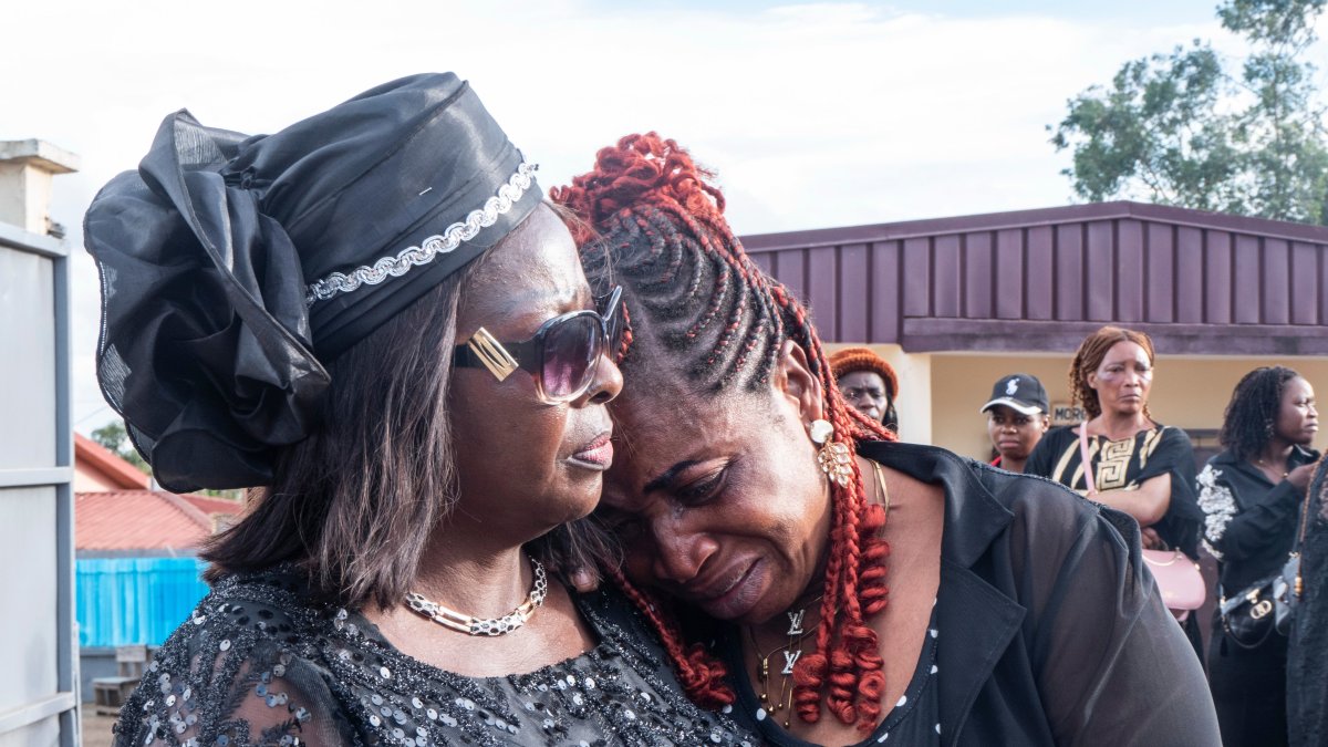 Mbatiabuh Regina Ngakum, sister of murdered woman Achiah Geraldine, is comforted as she grieves outside a mortuary chapel, Yaounde, Cameroon, Sept. 18, 2026. (AP Photo)