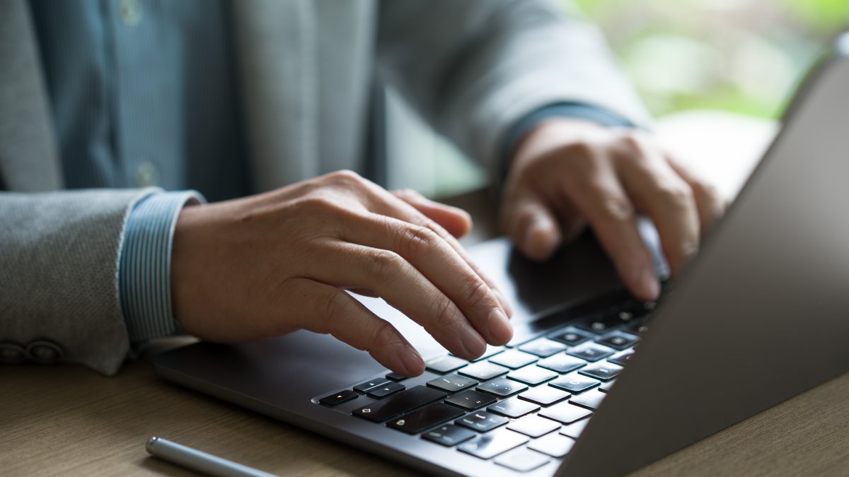 A man works at a computer amid growing concerns over AI-driven disinformation. (Shutterstock Photo)