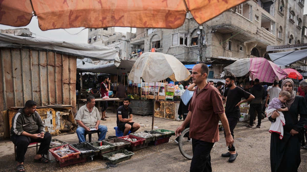 Palestinians walk through a market in the Al-Shati refugee camp, Gaza City, Palestine, Oct. 14, 2026. (AP Photo)