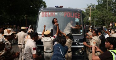 A protester reacts as she tries to stop the police bus carrying detained protesters during a protest organized by the Cockroach Janta Party (CJP), New Delhi, India, Oct. 10, 2026. (Reuters Photo)