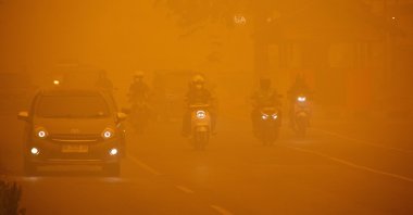 Motorists drive along a main road as haze from wildfires shrouds the area in Palangka Raya, Central Kalimantan province, Indonesia, Oct. 14, 2026. (Reuters Photo)