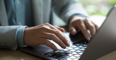 A man works at a computer amid growing concerns over AI-driven disinformation. (Shutterstock Photo)