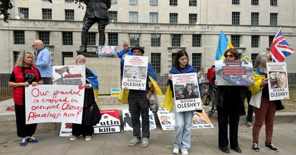 Larysa, 72, Oleshky resident who fled the town shortly after Russia's full-scale invasion of Ukraine in February 2022, holds posters as she participates in a rally demanding the establishment of a humanitarian corridor to evacuate Ukrainian civilians from her hometown, where her husband remains, amid Russia's attack on Ukraine, in London, Britain, Sept. 27, 2026. (Reuters Photo)
