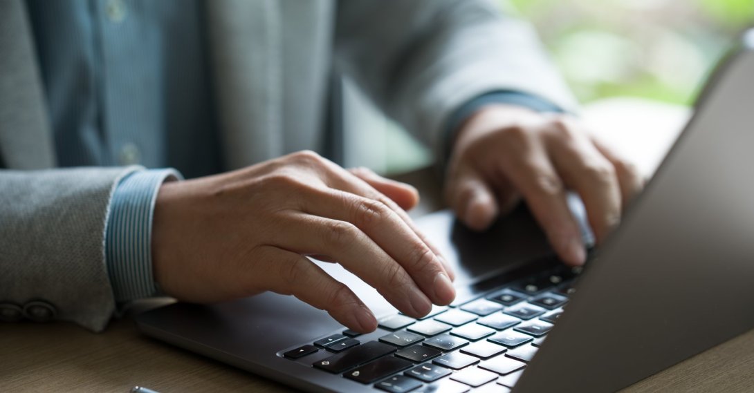 A man works at a computer amid growing concerns over AI-driven disinformation. (Shutterstock Photo)