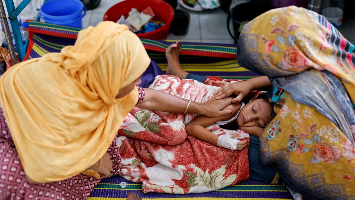 Relatives comfort six-year-old Istiyak Mahmud Zayan, who is receiving treatment on the floor of the overcrowded measles isolation ward of Shahid Shamsuddin Ahmed Hospital after developing symptoms of measles, Sylhet, Bangladesh, Sept. 12, 2026. (Reuters Photo)