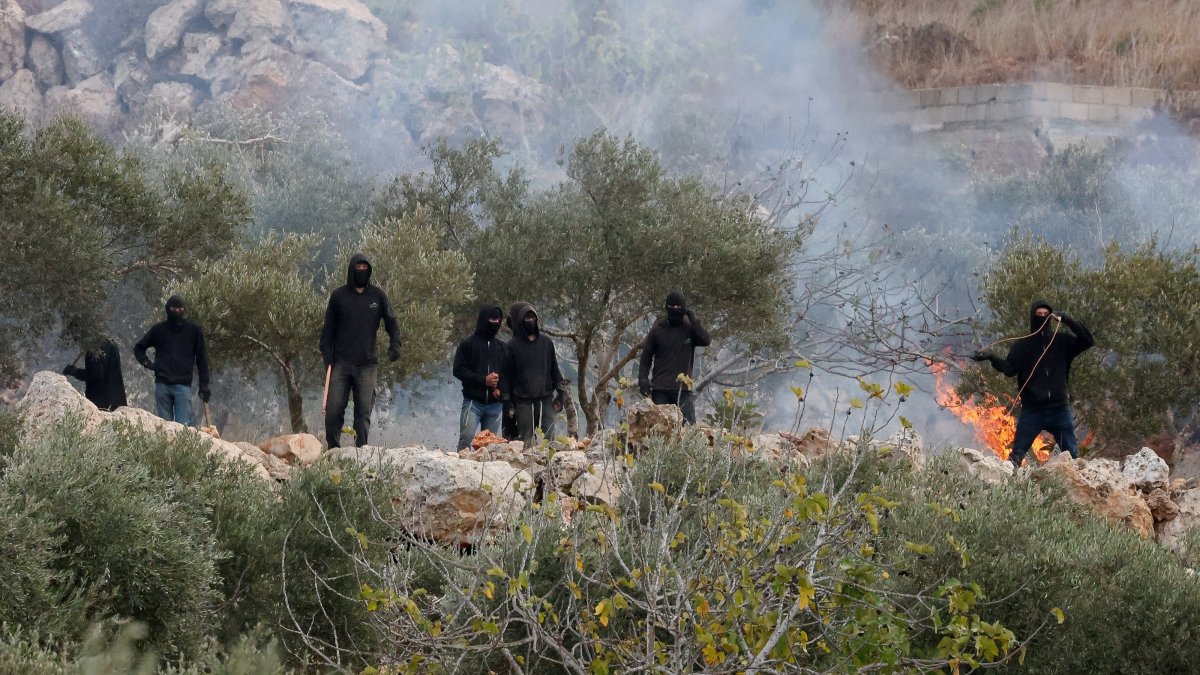 Israeli settlers next to a fire amid clashes with Palestinians during the olive harvest in Abu Falah near Ramallah, West Bank, Palestine, Oct. 16, 2026. (Reuters Photo)