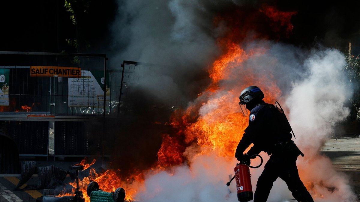 A police officer tries to extinguish a trash can fire during a demonstration to protest against the "high cost of living", Paris, France, Oct. 17, 2026. (AFP Photo)