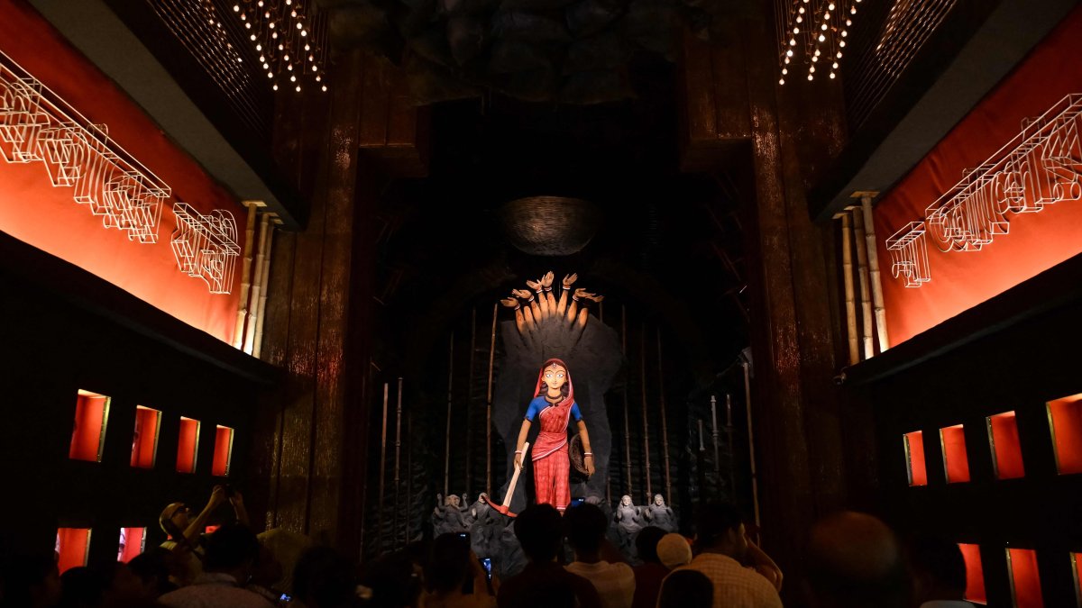 Devotees take photographs of an idol of the Hindu goddess 'Durga' at a pandal, a temporary shed set up for worship during the Durga Puja festival in Kolkata, Oct.16, 2026. (AFP Photo)