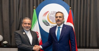 Foreign Minister Hakan Fidan shakes hands with Iranian Foreign Minister Abbas Araghchi on the sidelines of the 52nd Session of the Council of Foreign Ministers (CFM) of the Organisation of Islamic Cooperation (OIC) in Baghdad. (Photo by Turkish Foreign Ministry Press Service via AFP)