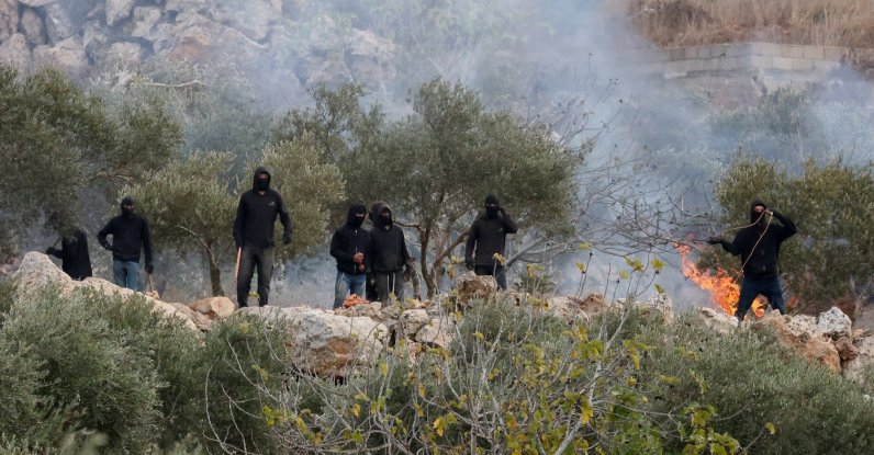 Israeli settlers next to a fire amid clashes with Palestinians during the olive harvest in Abu Falah near Ramallah, West Bank, Palestine, Oct. 16, 2026. (Reuters Photo)