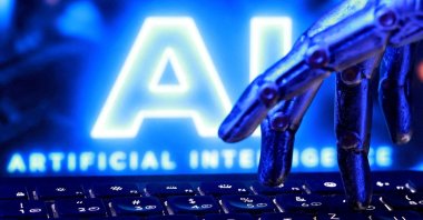 "AI Artificial Intelligence" wording, a keyboard and a robotics hand are seen in this illustration created on Sept. 23, 2026. (Reuters Photo)