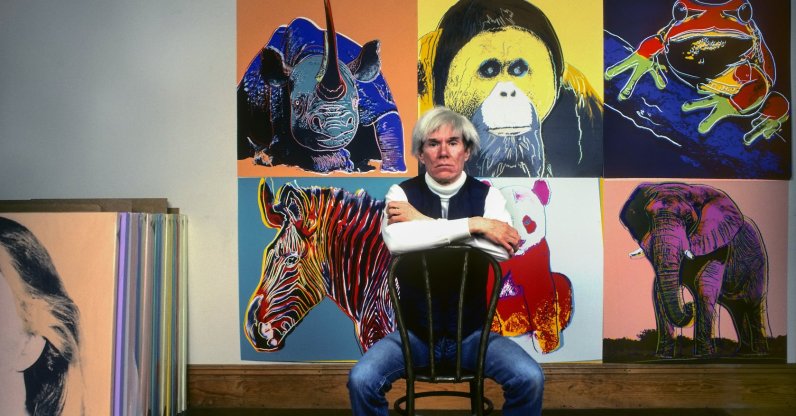 American Pop artist Andy Warhol sits in front of several paintings in his "Endangered Species" series at his studio, the Factory, Union Square, New York, U.S., April 12, 1983. (Getty Images Photo)