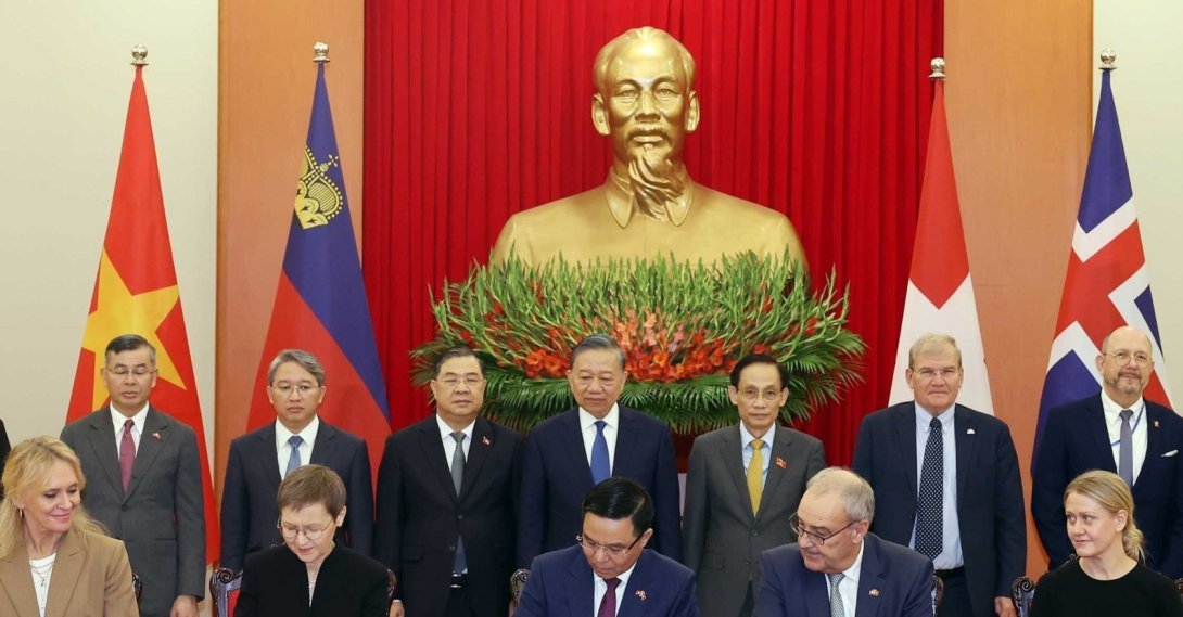 Switzerland's President Guy Parmelin, seated second right, and Vietnamese President To Lam, standing center, watch the signing of the Vietnam-EFTA Free Trade Agreement in Hanoi, Vietnam, Oct. 18, 2026. (AP Photo)