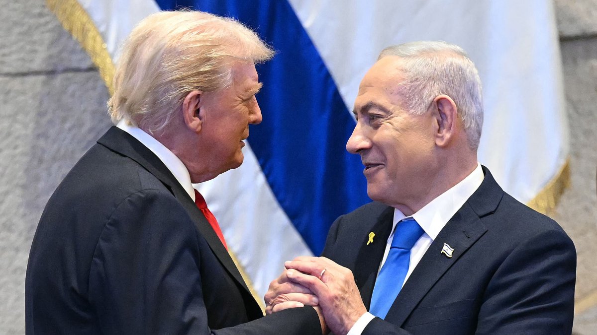U.S. President Donald Trump (L) holds hands and speaks with Israeli Prime Minister Benjamin Netanyahu at the Israeli parliament, the Knesset, in Jerusalem, Oct. 13, 2025. (AFP Photo)