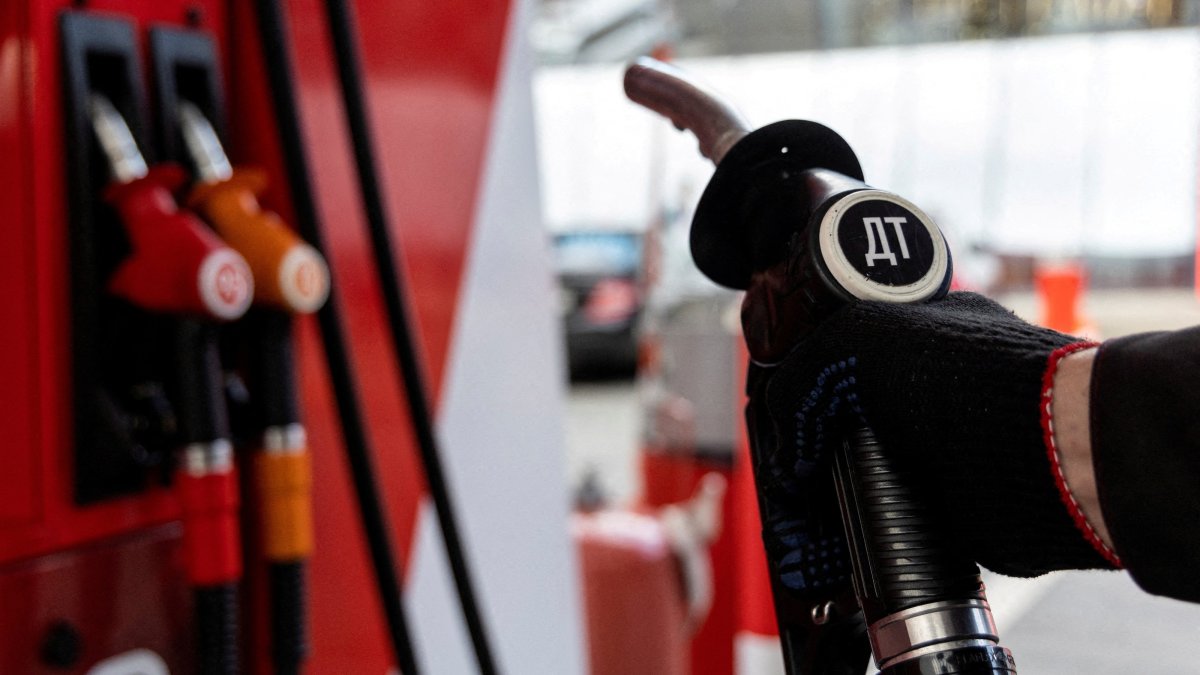 An employee holds a diesel fuel pump nozzle at a petrol station of Neftmagistral company in Moscow, Russia, Sept. 8, 2023. (Reuters Photo)