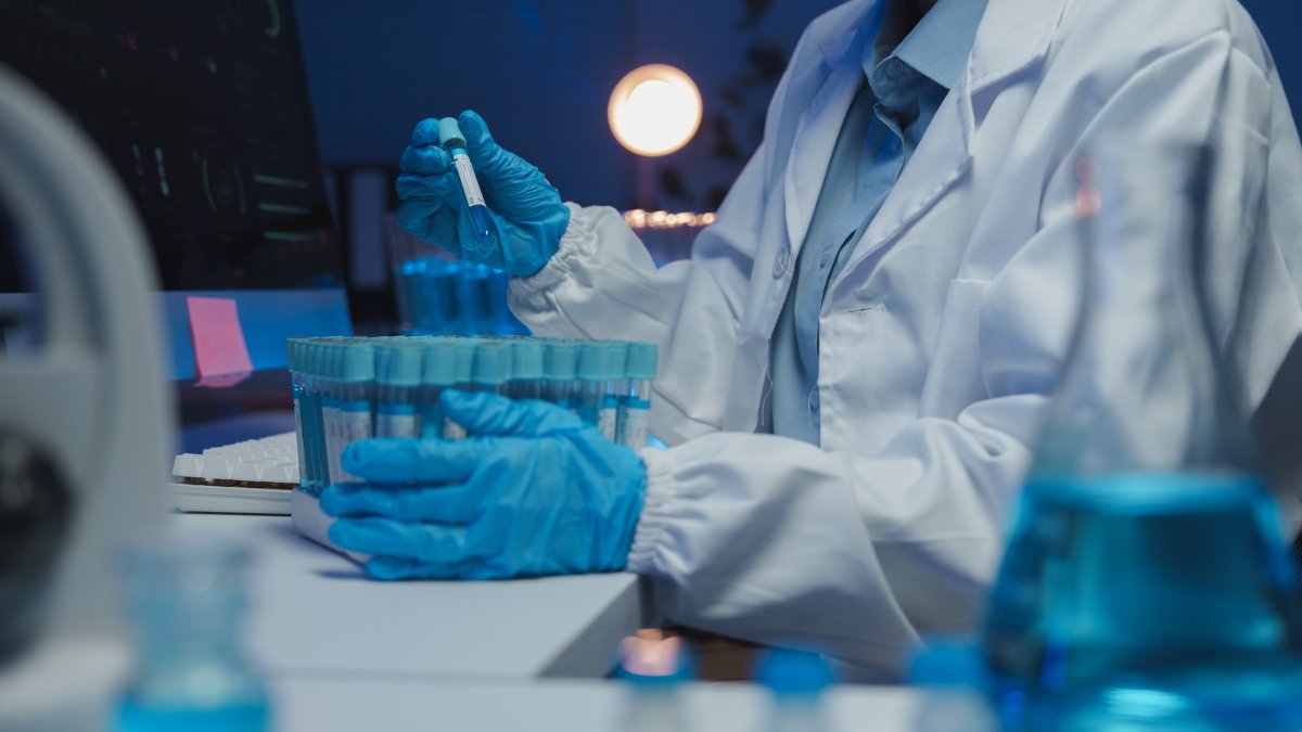 A scientist handles test tubes during laboratory research. (Shutterstock Photo)