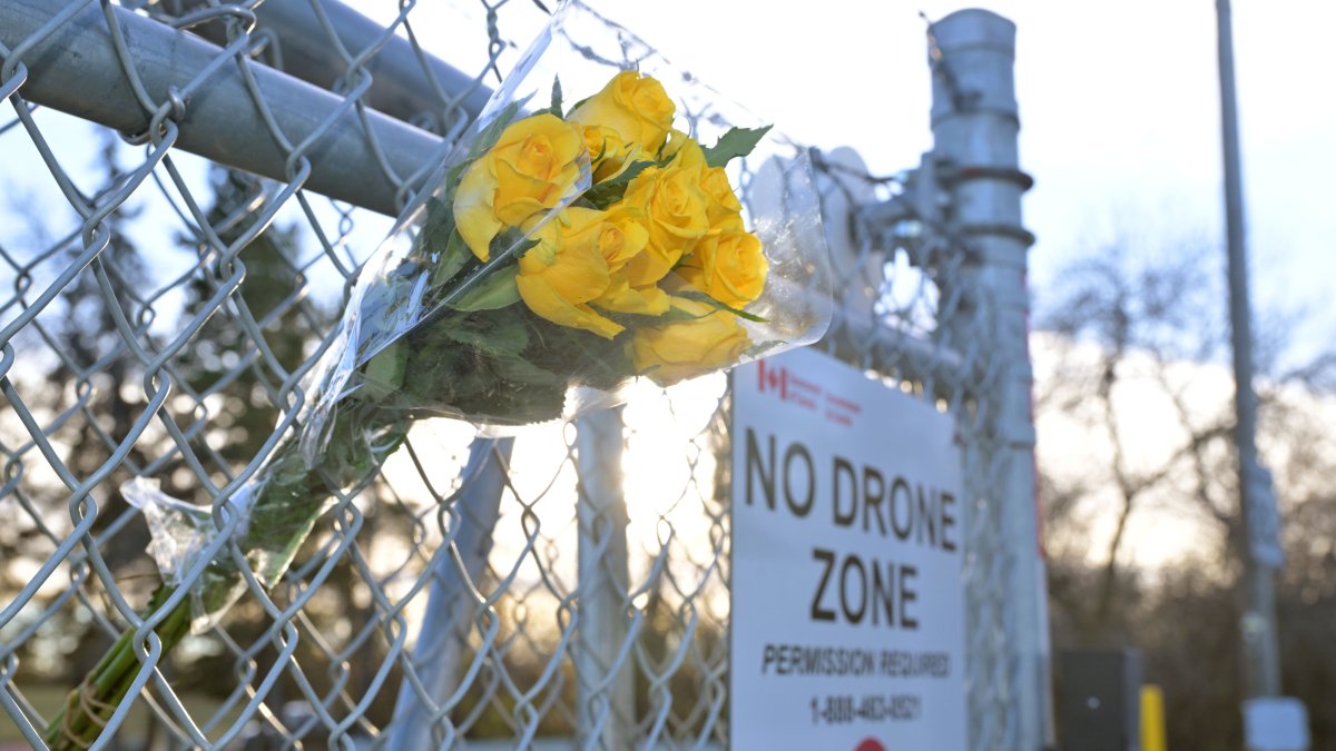 A bouquet of flowers sits on the fence by the main entrance to the military base in Wainwright, Alberta, Canada, Oct. 18, 2026. (EPA Photo)