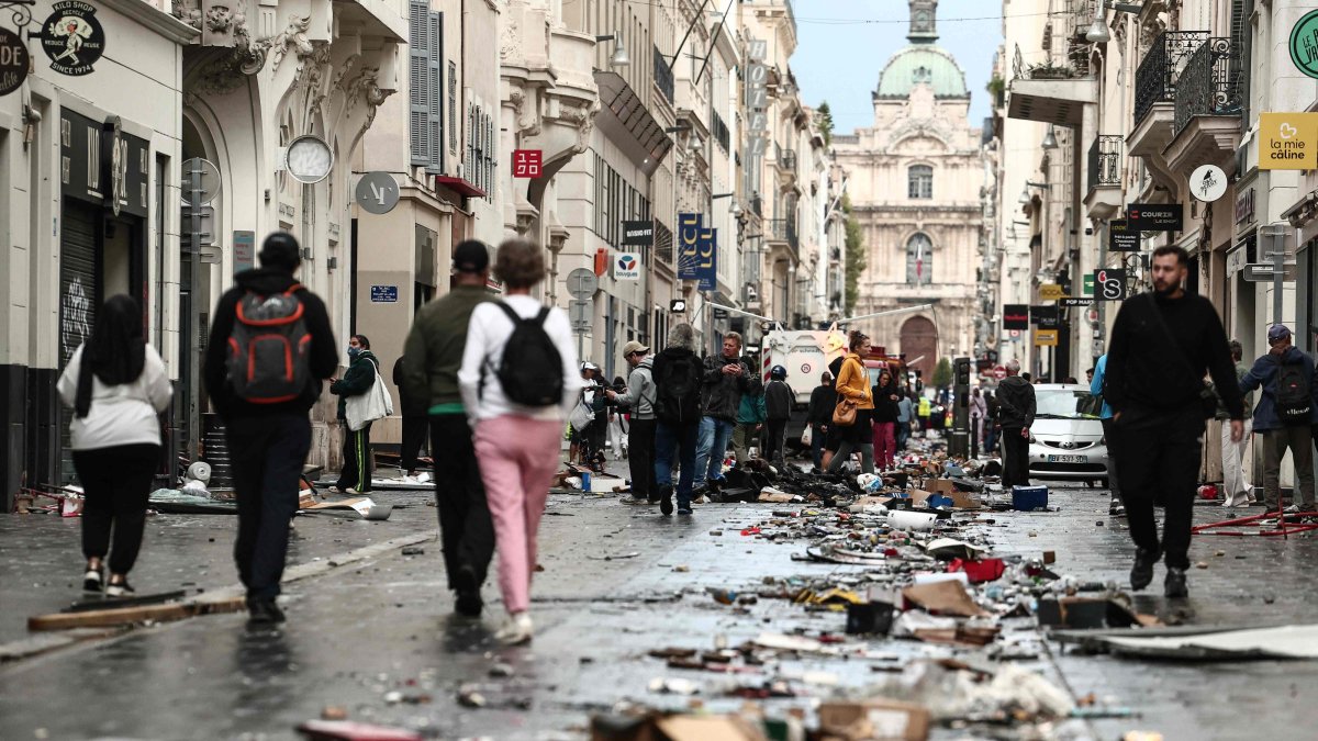 Pedestrians walk along a street covered in debris a day after nationwide protests against the "high cost of living" in Marseille, France, Oct. 18, 2026. (AFP Photo)