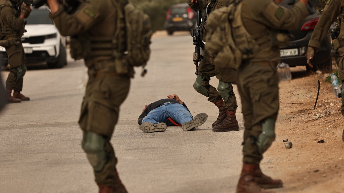 Israeli soldiers surround a Palestinian farmer who was shot by the Israeli army following a terrorist settlers' attack on families harvesting their olive trees in Abu Falah, West Bank, Oct. 16, 2026.  (EPA Photo)