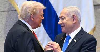 U.S. President Donald Trump (L) holds hands and speaks with Israeli Prime Minister Benjamin Netanyahu at the Israeli parliament, the Knesset, in Jerusalem, Oct. 13, 2025. (AFP Photo)
