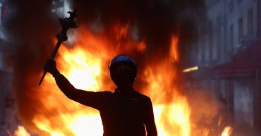 A person raises their arm during civil unrest, the day after a national day of demonstrations against the cost of living and rising fuel prices, in Paris, France, Oct. 18, 2026. (Reuters Photo)