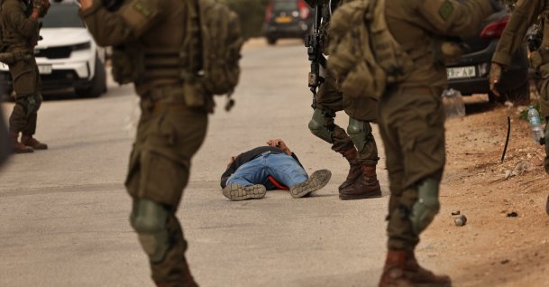  Israeli soldiers surround a Palestinian farmer who was shot by the Israeli army following a terrorist settlers' attack on families harvesting their olive trees in Abu Falah, West Bank, Oct. 16, 2026.  (EPA Photo)