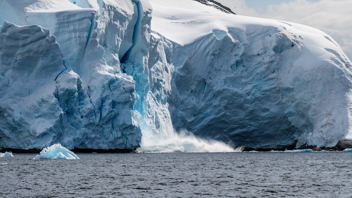 A giant chunk of ice breaking away from an ice sheet in Graham Passage, near Charlotte Bay, Antarctic Peninsula, Antarctica. (Shutterstock Photo)